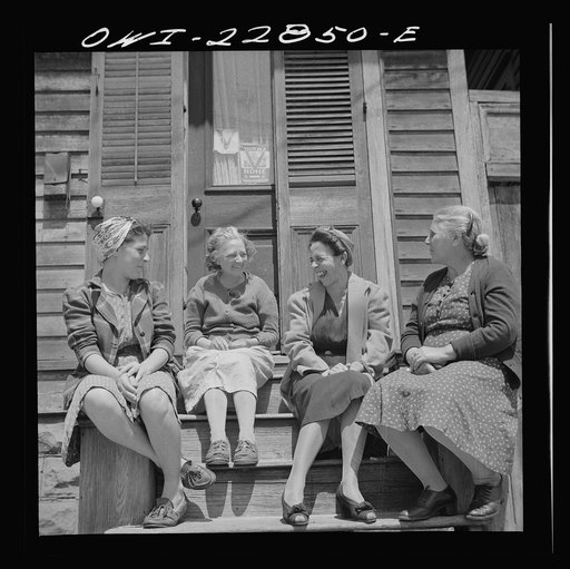 New Orleans, Louisiana. Woman talking in front of a home