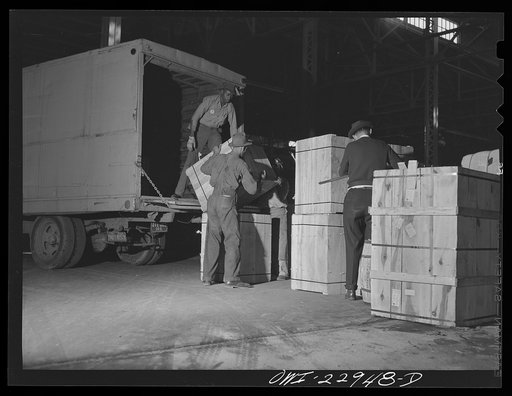 Untitled photo, possibly related to: New Orleans, Louisiana. Trucks unloading goods in a warehouse at the Poydras Street dock