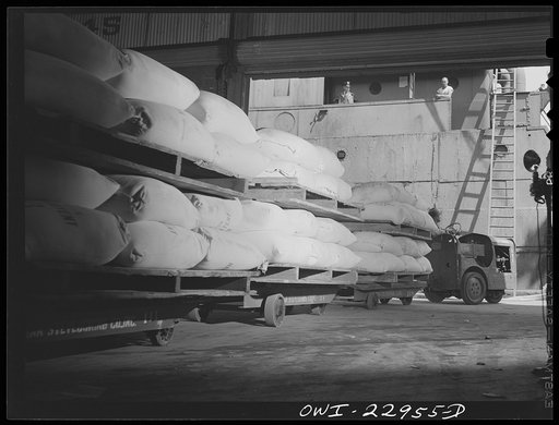New Orleans, Louisiana. Sacks of flour being loaded onto a ship at the Poydras Street dock