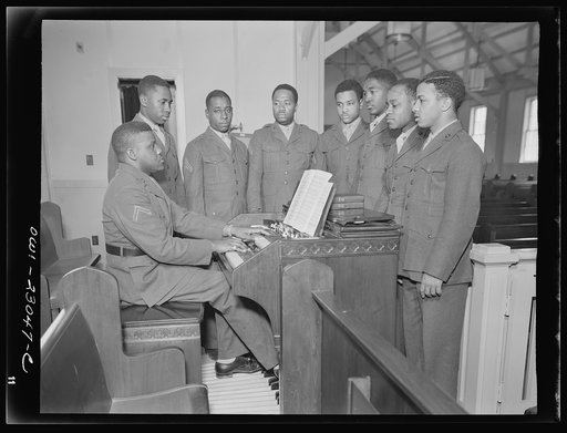 Camp Lejeune, New River, North Carolina. Private First Class Walker Manly, organist, rehearsing with members of the 51st Composite Battalion for a camp chapel service