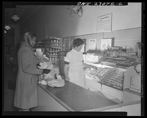 Untitled photo, possibly related to: Washington, D.C. By constructing three partitions in a cheese box this retailer has made a simple container for red stamps, which must be surrendered by customers under the point rationing system