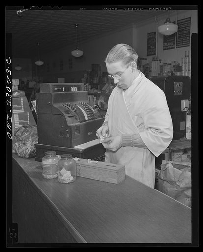 Untitled photo, possibly related to: Washington, D.C. By constructing three partitions in a cheese box this retailer has made a simple container for red stamps, which must be surrendered by customers under the point rationing system