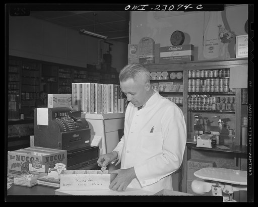 Washington, D.C. By constructing three partitions in a cheese box this retailer has made a simple container for red stamps, which must be surrendered by customers under the point rationing system