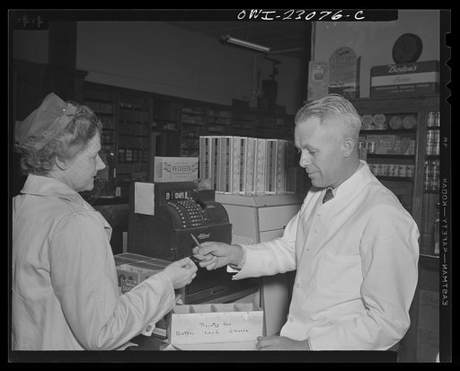 Untitled photo, possibly related to: Washington, D.C. By constructing three partitions in a cheese box this retailer has made a simple container for red stamps, which must be surrendered by customers under the point rationing system