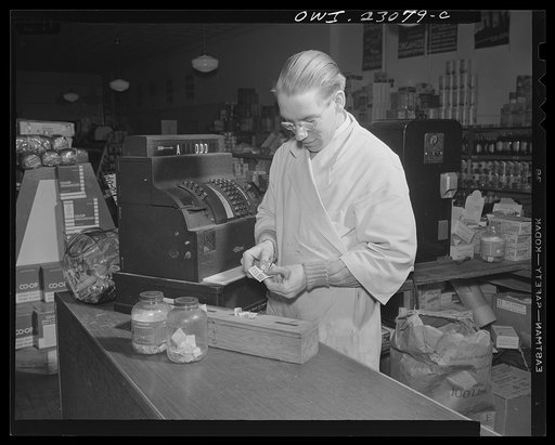 Washington, D.C. Coffee jars with slots in the lids are used for sugar and coffee stamps. A homemade plywood box with dotted cover and compartments is used for blue stamps, which must be surrendered by customers under the point system