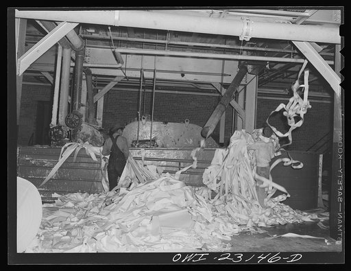 Untitled photo, possibly related to: Lufkin, Texas. Southland paper mill. Placing trimmed edges of newsprint rolls into a vat where they are converted back into stock