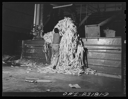 Lufkin, Texas. Southland paper mill. Placing trimmed edges of newsprint rolls into a vat where they are converted back into stock