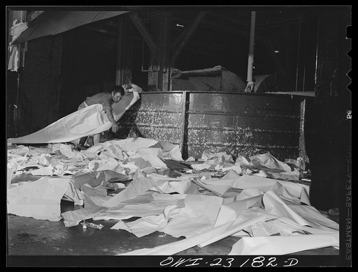Untitled photo, possibly related to: Lufkin, Texas. Southland paper mill. Placing trimmed edges of newsprint rolls into a vat where they are converted back into stock