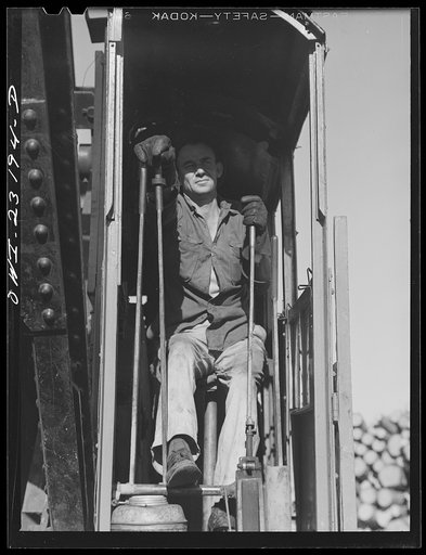 Lufkin, Texas. Southland paper mill. Crane operator unloading a flat car of pulpwood in the wood yard
