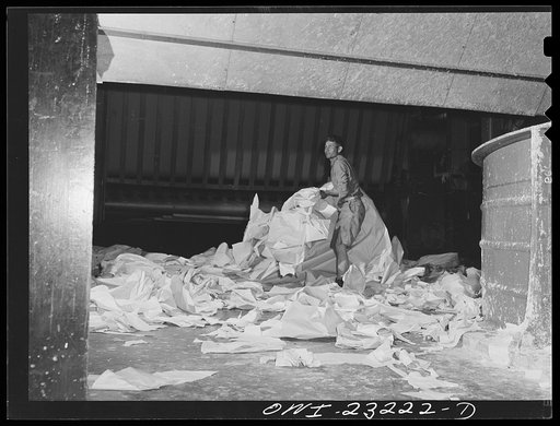 Untitled photo, possibly related to: Lufkin, Texas. Southland paper mill. Placing trimmed edges of newsprint rolls into a vat where they are converted back into stock