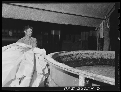 Untitled photo, possibly related to: Lufkin, Texas. Southland paper mill. Placing trimmed edges of newsprint rolls into a vat where they are converted back into stock
