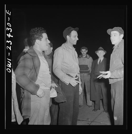 Baltimore, Maryland. Third shift defense workers waiting on the corner where their car pools will pick them up around midnight