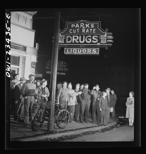 Baltimore, Maryland. Third shift workers waiting on a street corner to be picked up by car pools around midnight
