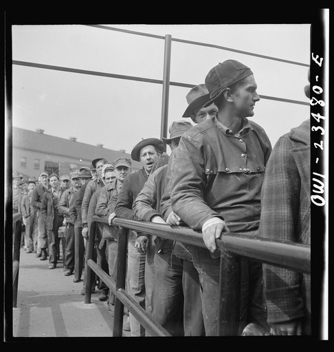 Bethlehem-Fairfield shipyards, Baltimore, Maryland. Lining up before a time clock at the changing of the shifts