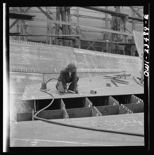 Bethlehem-Fairfield shipyards, Baltimore, Maryland. Chipper removing the welding beads where a lifting clip has been on an innerbottom unit