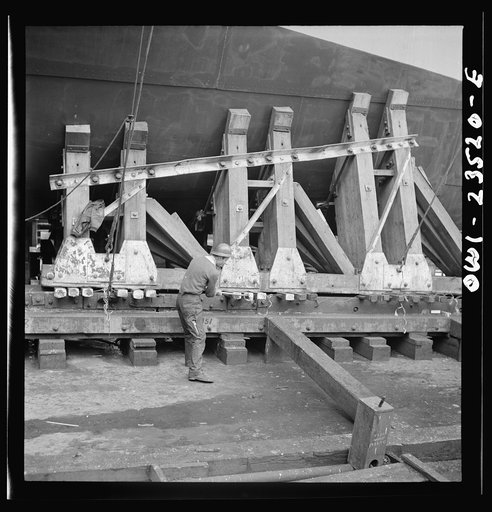 Bethlehem-Fairfield shipyards, Baltimore, Maryland. Driving wedges under a poppet before a launching