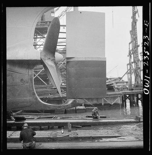 Bethlehem-Fairfield shipyards, Baltimore, Maryland. Propeller and rudder just before a launching. Below, workmen are greasing the outboard end of the ways