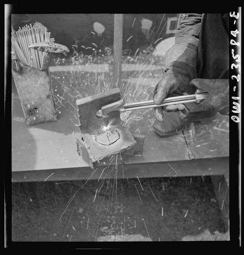 Bethlehem-Fairfield shipyards, Baltimore, Maryland. Burning a hole in a lifting ship