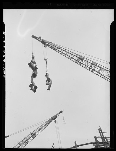 Bethlehem-Fairfield shipyards, Baltimore, Maryland. Lifting piping to a ship