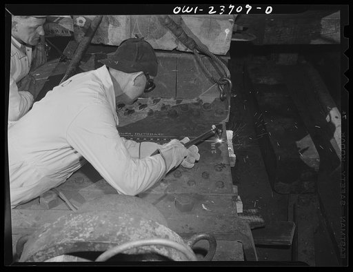 Bethlehem-Fairfield shipyards, Baltimore, Maryland. Burning through the tie plate, the last length to hold the ship on the ways, just before launching her