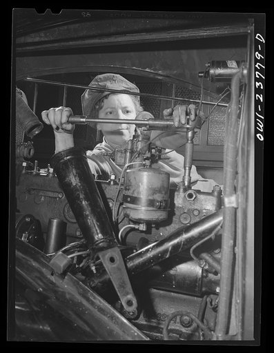 Buffalo, New York. Woman learning to be an automobile mechanic at the Burgard Vocational High School. She is drawing down the cylinder head of an automotive engine with the use of a toisinal wrench