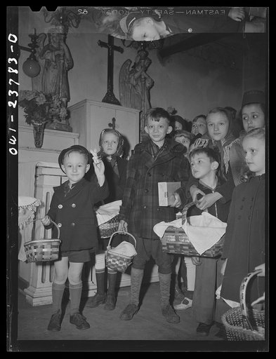 Buffalo, New York. Children of the Polish community waiting in church on the day before Easter with baskets of food to be blessed by the priest. The breaking of fasting after Lent is most important to Poles who consider Easter a day of church-going, feasting and visiting