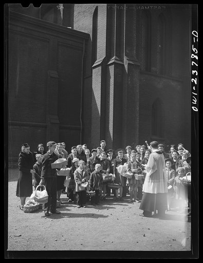 Untitled photo, possibly related to: Buffalo, New York. Priest blessing baskets of food outside the church in the Polish community on the day before Easter. The ceremony celebrates the breaking of Lent in fasting. The food is eaten on Easter day