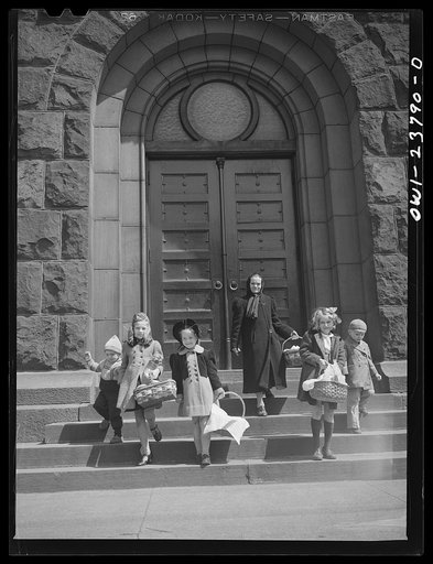 Buffalo, New York. Children of the Polish community leaving church with baskets of food on the day before Easter. The food has been blessed by the priest to celebrate the breaking of Lenten fasting, and is eaten Easter day