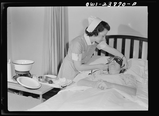 Student nurse, Frances Bullock adjusts an eye shield for a post-operative patient after the dressing has been changed. Thousands of additional young women between the ages of seventeen and thirty-five must be recruited this year to relieve the storage of graduate trained nurses