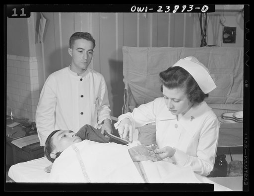 Second Lieutenant Frances Bullock applies a dressing to a wounded soldier's hand in an Army hospital