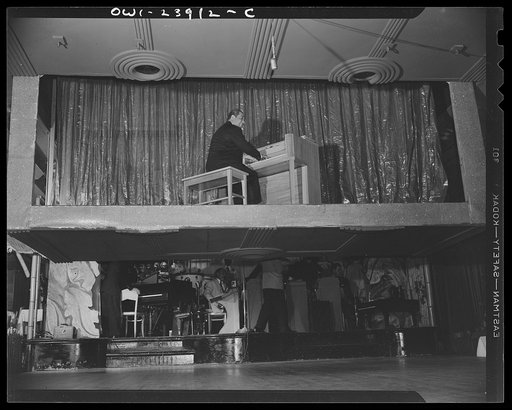 New York, New York. Duke Ellington descending from the ceiling of the Hurricane cabaret playing a medley of his own compositions during a floor show