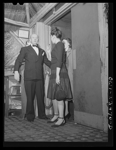 New York, New York. The head waiter at the Hurricane ushers in a party