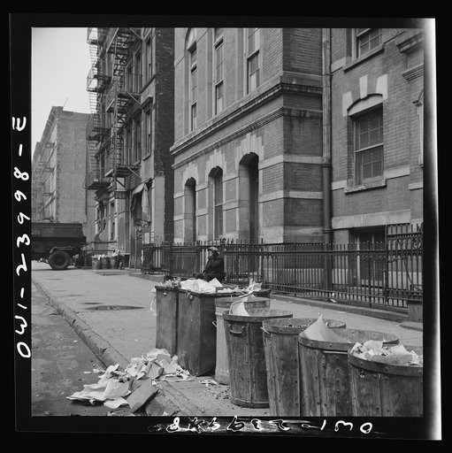 New York, New York. Street scene showing open trash cans along the curb
