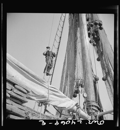 New York, New York. Gloucester fisherman standing in the rigging of a New England fishing boat
