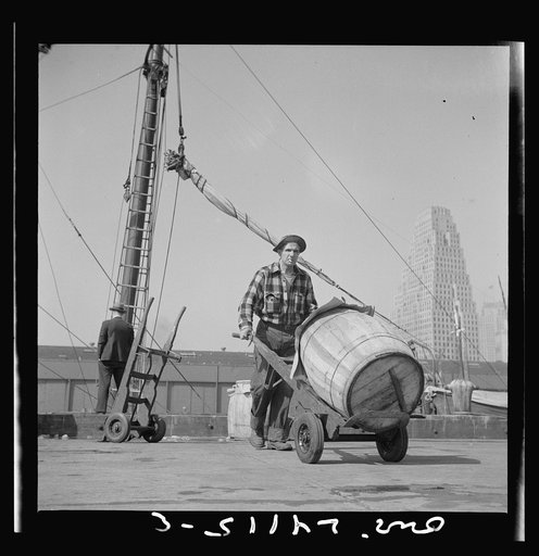 New York, New York. Dock stevedore at the Fulton fish market moving a barrel of codfish