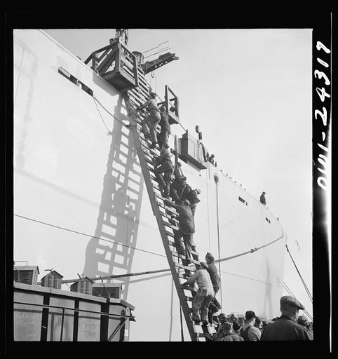 Bethlehem-Fairfield shipyards, Baltimore, Maryland. Workers ascending a ladder at the outfitting pier