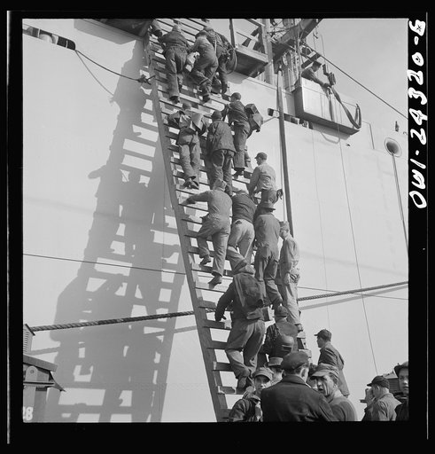 Bethlehem-Fairfield shipyards, Baltimore, Maryland. Workers on a ladder at the outfitting pier