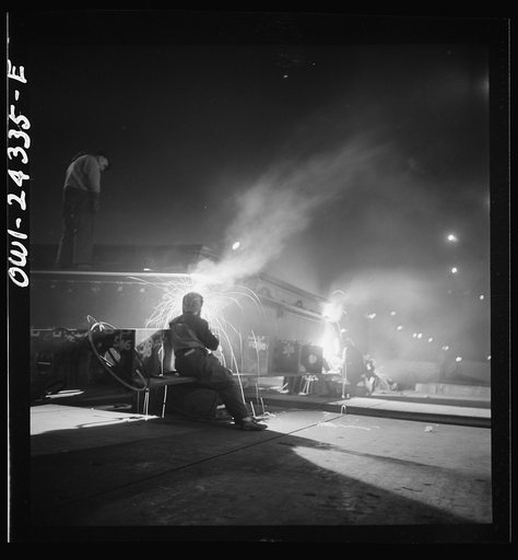 Baltimore, Maryland. Third shift workers waiting on street corner to be picked up by shared cars around midnight