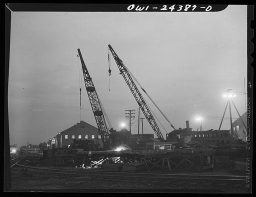 Bethlehem-Fairfield shipyards, Baltimore, Maryland. Railroad cranes at work at night