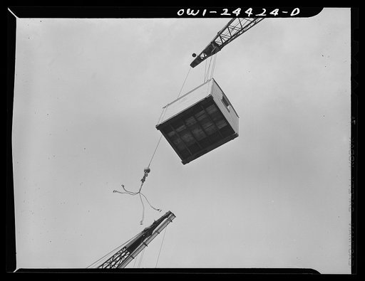 Bethlehem-Fairfield shipyards, Baltimore, Maryland. Lowering a tool shack onto a deck