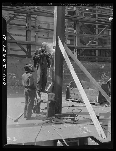 Bethlehem-Fairfield shipyards, Baltimore, Maryland. Welding a clip on the engine room stanchion