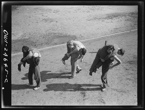 Benjamin Franklin High School, New York, New York. Boys in the "commando" course, part of the physical education program, learning the fireman's "carry," or the correct method of carrying a wounded comrade