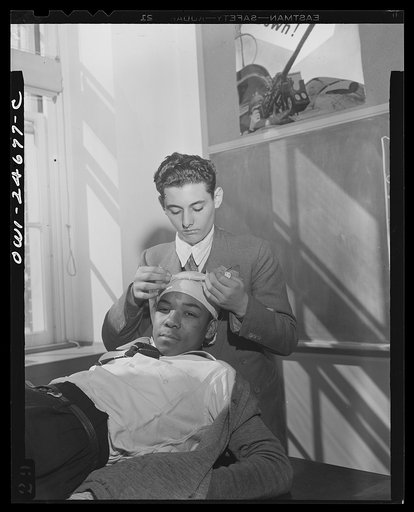 Untitled photo, possibly related to: Benjamin Franklin High School, New York, New York. Boys take one day a week from their English course for "war activities" in order to learn the basic principles of first aid