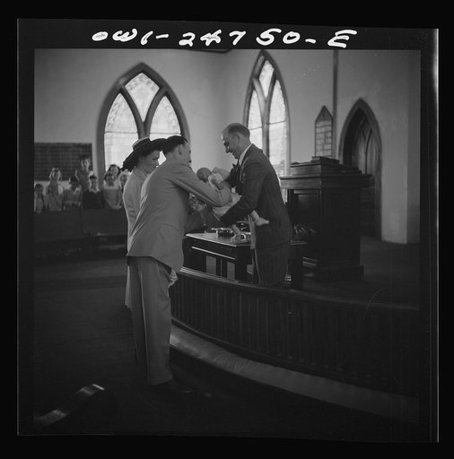 San Augustine, Texas. Reverend Dubberly taking an infant from its parents for the baptismal ceremony