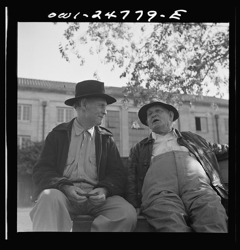 San Augustine, Texas. Men talking on a park bench in Courthouse Square