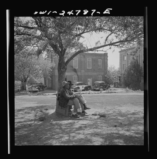 San Augustine, Texas. Men talking on a park bench in Courthouse Square