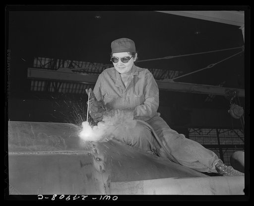 Milwaukee, Wisconsin. War production workers at the Heil Company making gasoline trailer tanks for the U.S. Army Air Corps. Enola O'Connell, age thirty-two, widow and mother of one child, welding part of a trailer. She is the only woman welder in the plant. This is her first job outside her house
