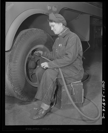 Milwaukee, Wisconsin. War production workers at the Heil Company making gasoline trailer tanks for the U.S. Army Air Corps. Mrs. Angeline Kwint, age forty-five, an ex-housewife, checking the tires of trailers. Her husband and son are in the U.S. Army