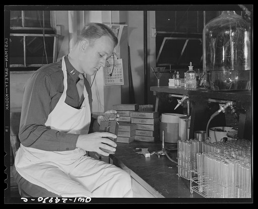 Chicago, Illinois. Subsistence research laboratory of the U.S. Army quartermaster depot. Captain C.M. Wilson, examining contents of a K ration