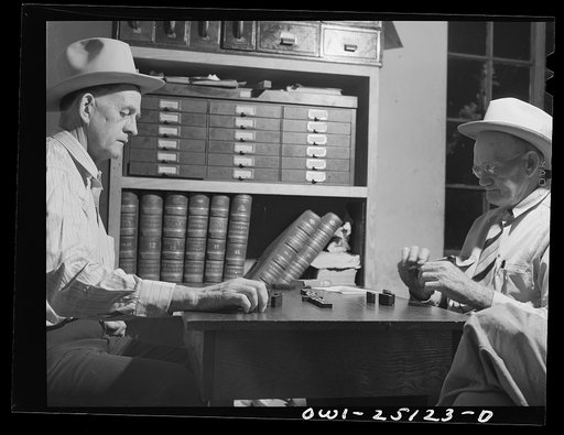 Untitled photo, possibly related to: San Augustine, Texas. Lud Behnholder, filling station operator, watching night marshall Jeff Davis and the Justice of the Peace H.L. Armstrong in a domino game